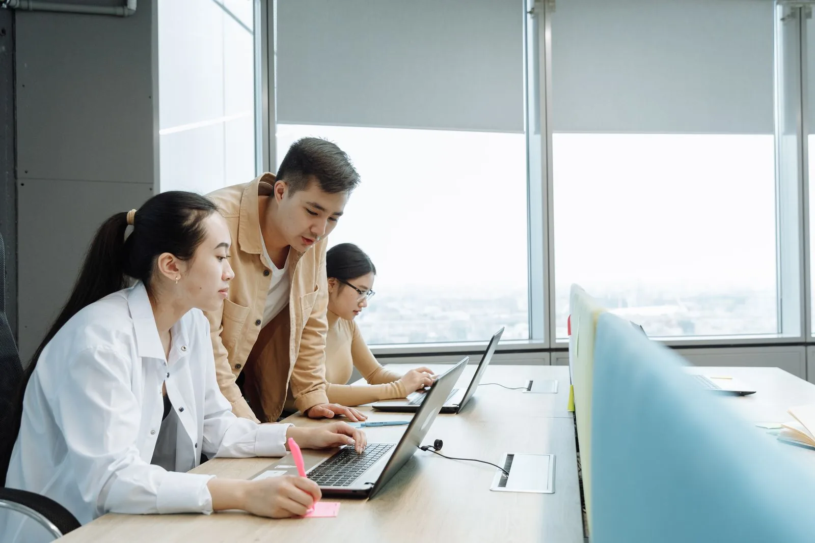 Asian office employees working together on a laptop to check records before unemployment benefits are paid